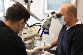 Dr. Janse using a root canal microscope during a procedure.