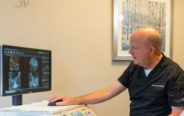 An image of best endodontist Dr. Janse examining a set of patient x-rays.